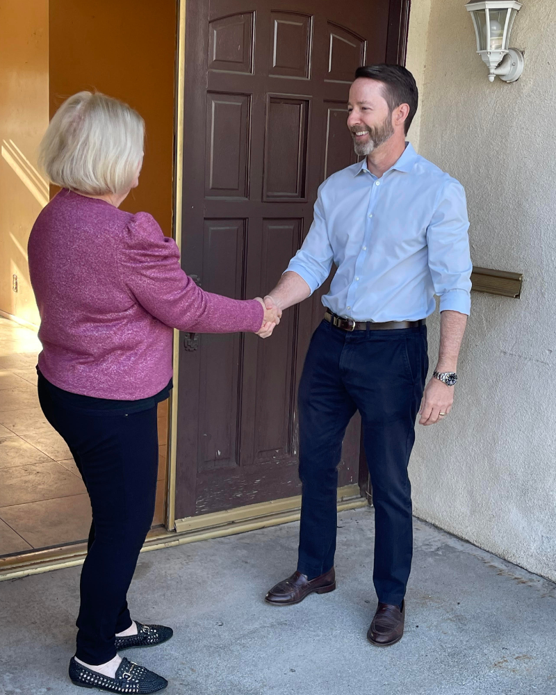 Eric Nerhood shaking hands with a seller at her front door